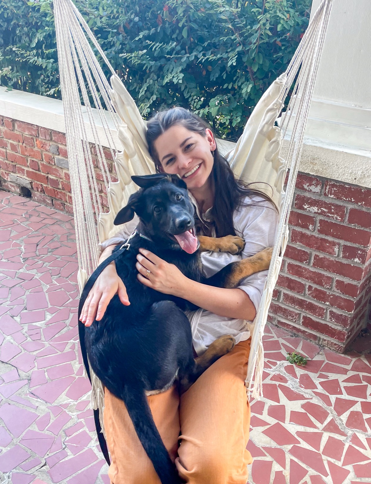 Abigail with her dog Birdie in a hammock chair