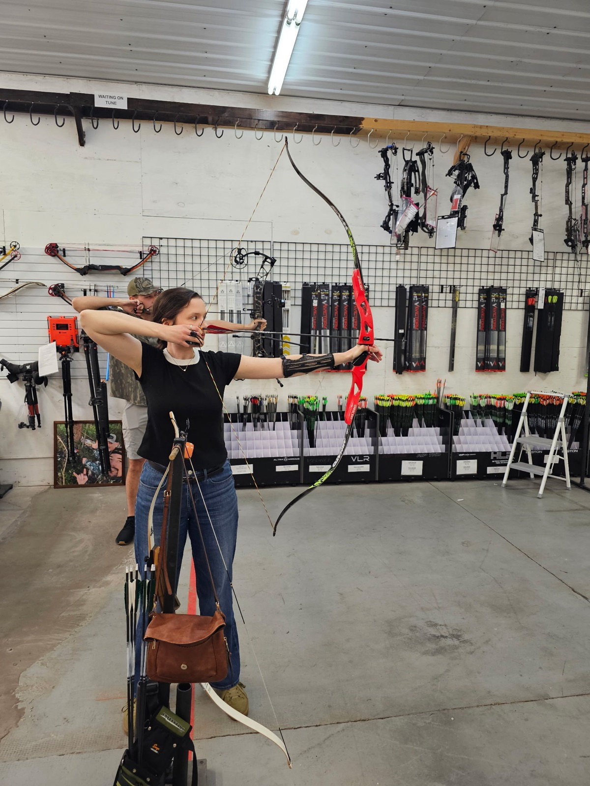 Amelia drawing a recurve bow at the archery range