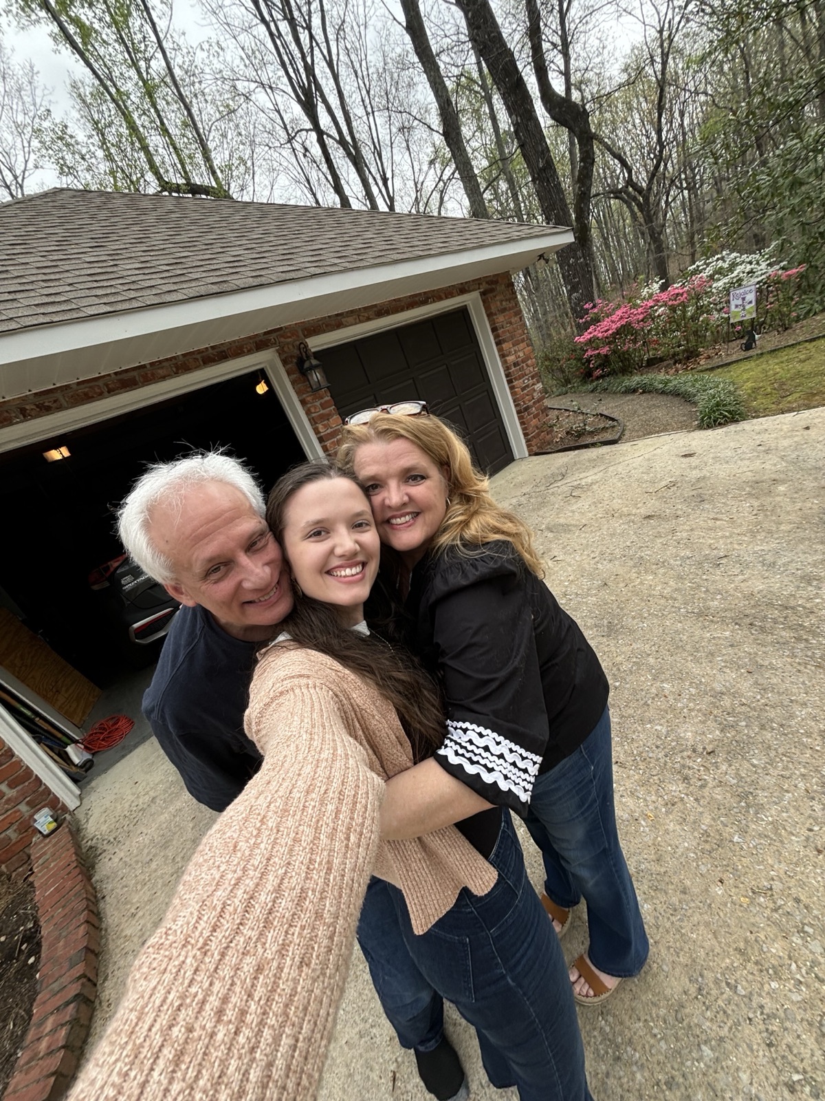 Amelia with her parents in their driveway