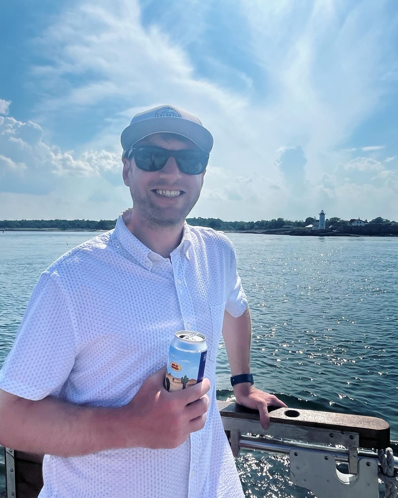 Beau on the water with a lighthouse behind him