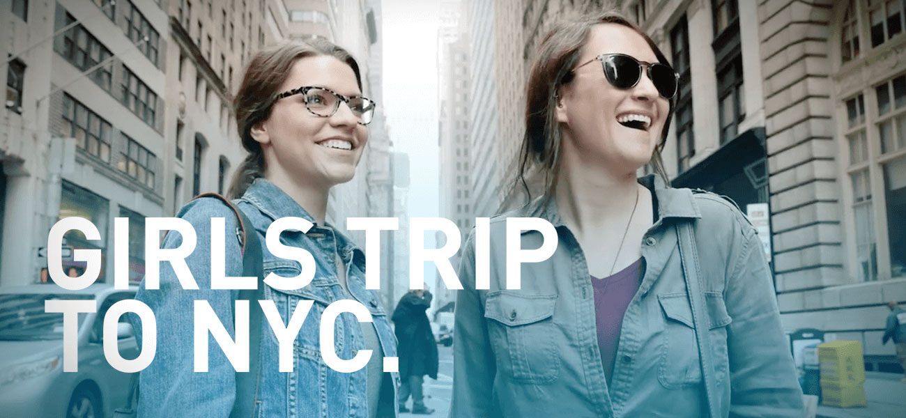 Airport campaign ad, two women laughing on a city street under the words Girls Trip to NYC