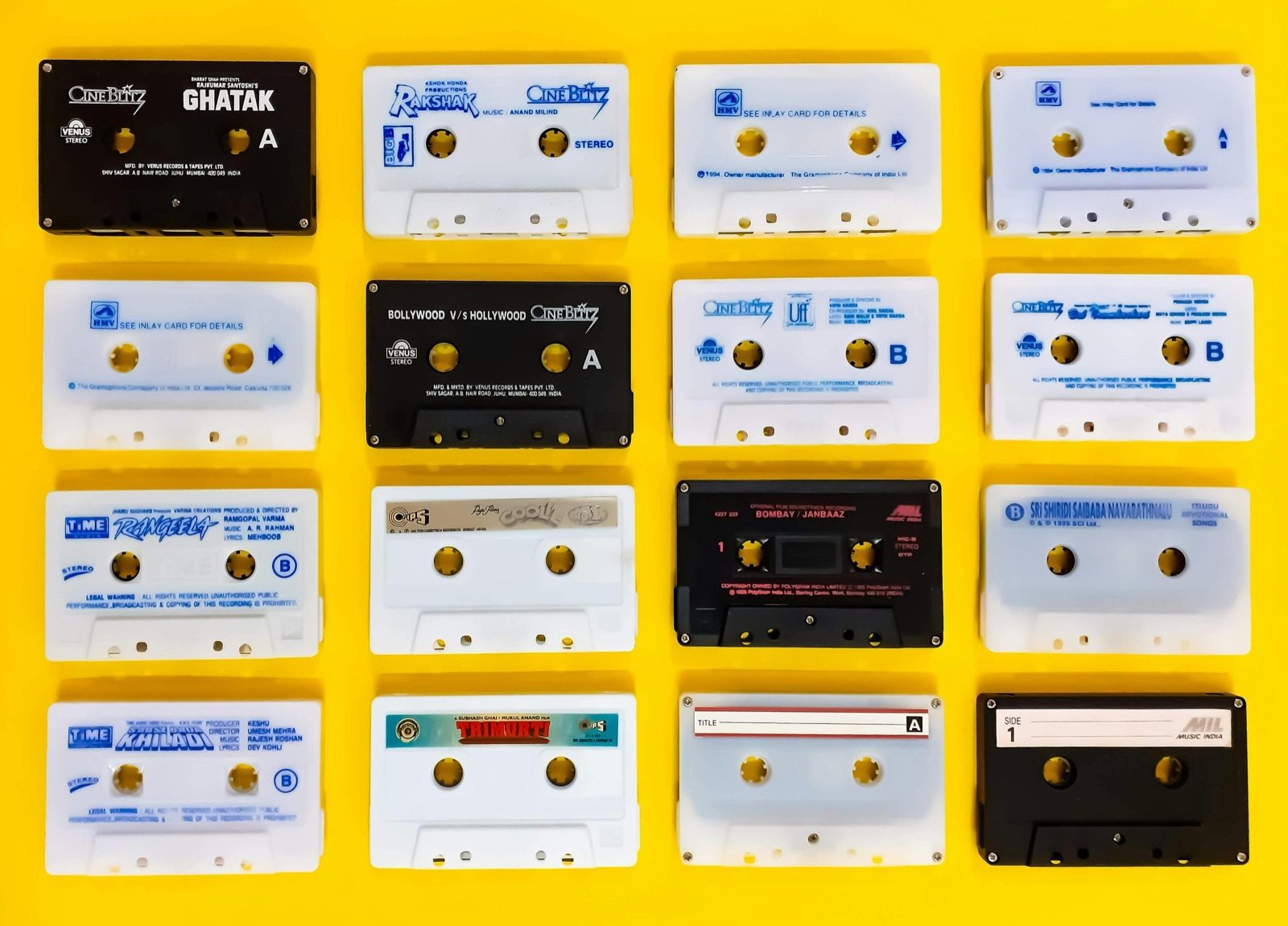 Grid of cassette tapes with handwritten labels on a yellow background