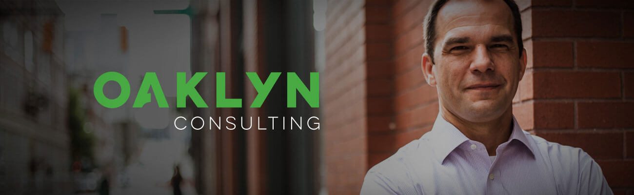Oaklyn Consulting logo beside a smiling man in a white shirt