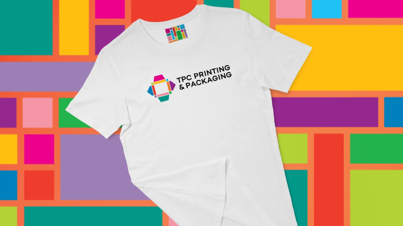 A white T-shirt printed with the TPC Printing and Packaging logo, on a background of colour blocks