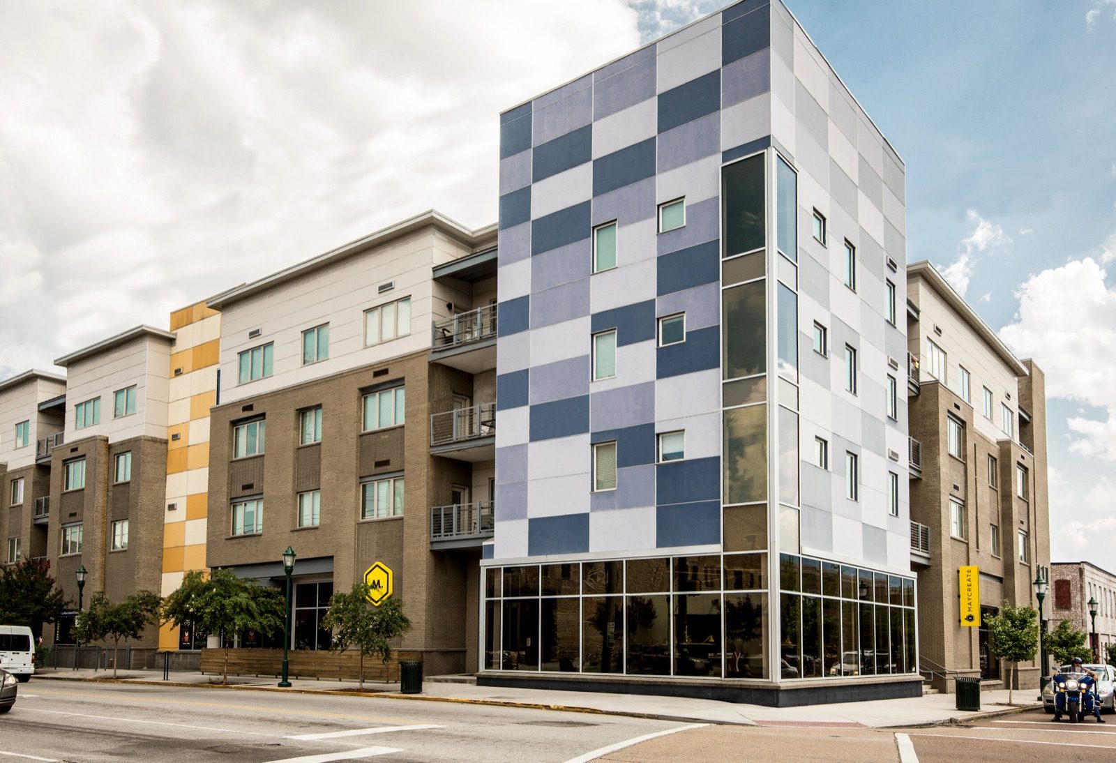Modern apartment building with a checkered blue and gray facade on a street corner