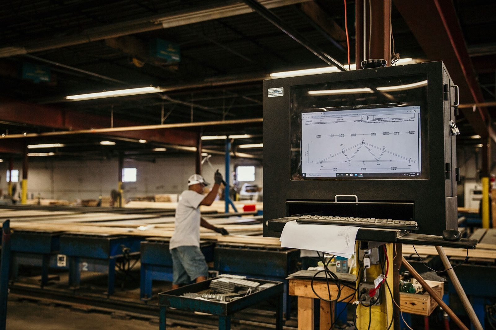 A worker at a computer-controlled saw station in the plant