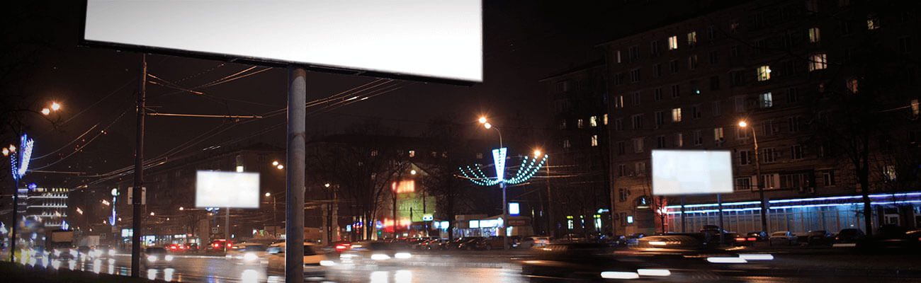Blank billboards over a city street at night