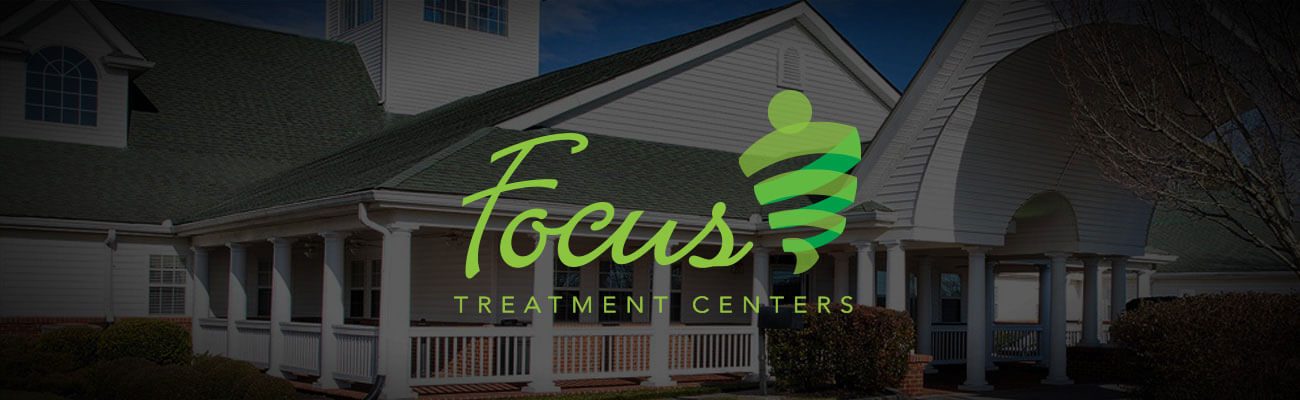 Focus Treatment Centers logo over a residential building at dusk