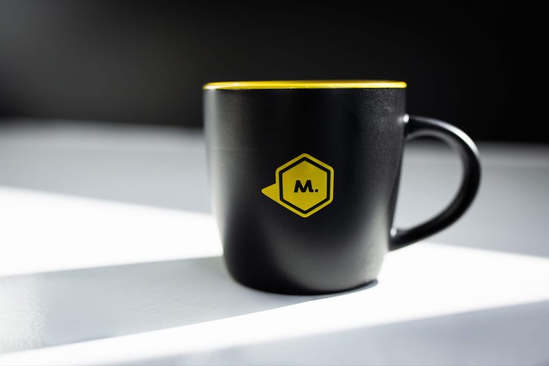 Black Maycreate mug with a yellow rim and M logo