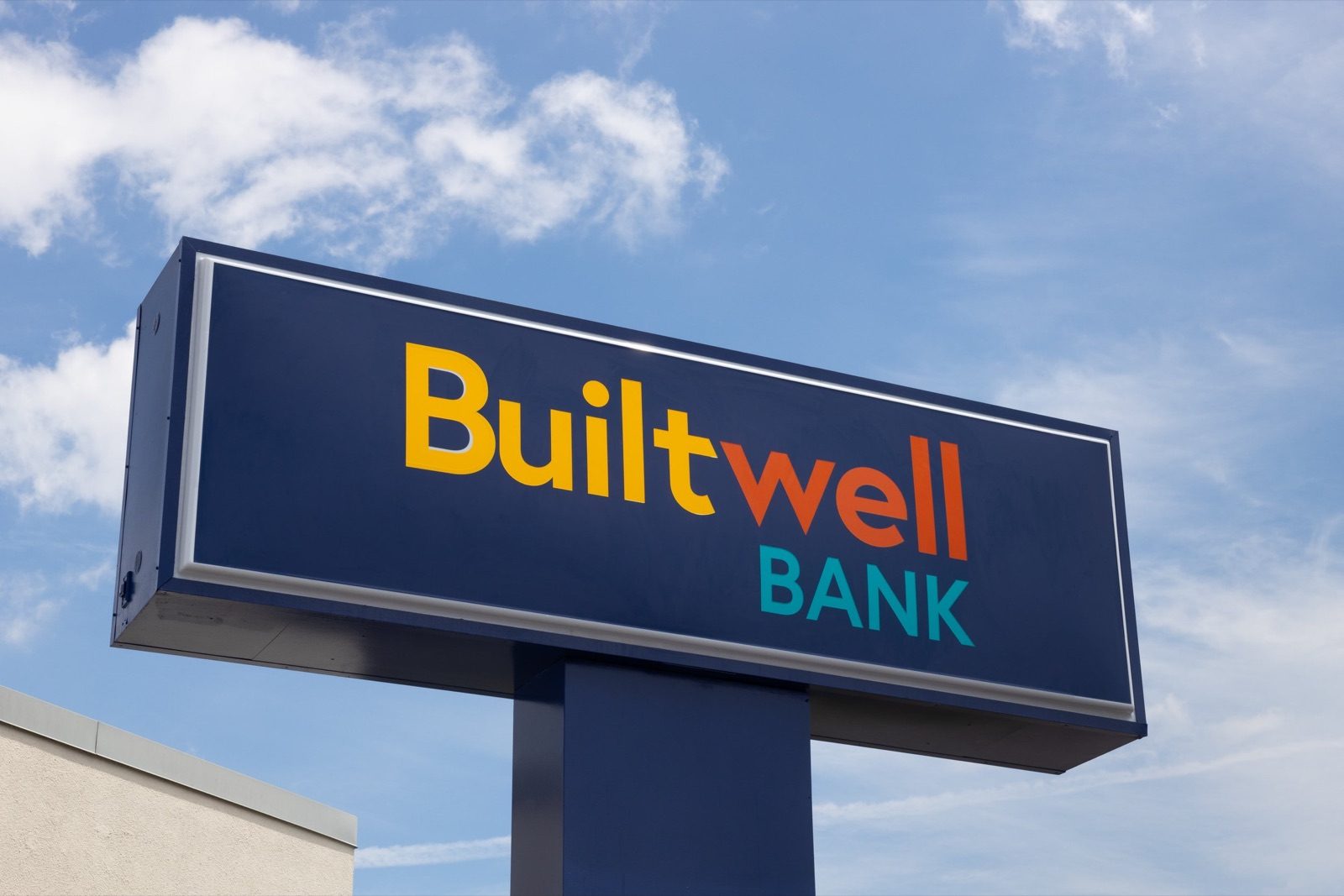 Builtwell Bank sign on a pole against a blue sky