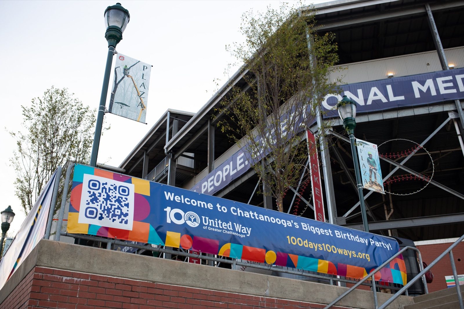 Colorful United Way banner on a stadium concourse: Welcome to Chattanooga's Biggest Birthday Party, 100 days 100 ways