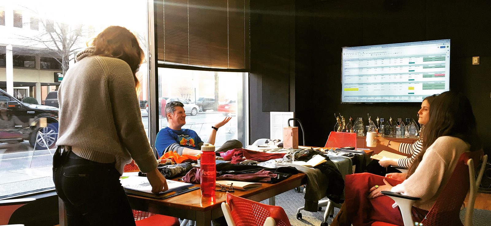 People working around a table in a cafe with a whiteboard behind them