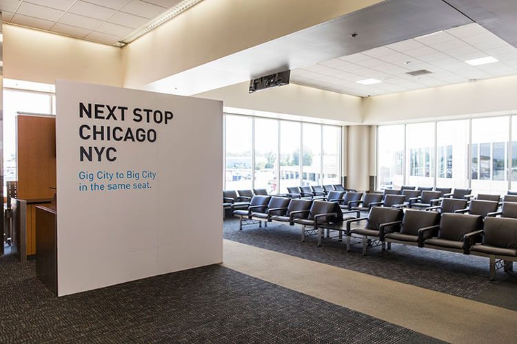 Gate-area wall graphic reading Next Stop Chicago NYC, Gig City to Big City in the same seat