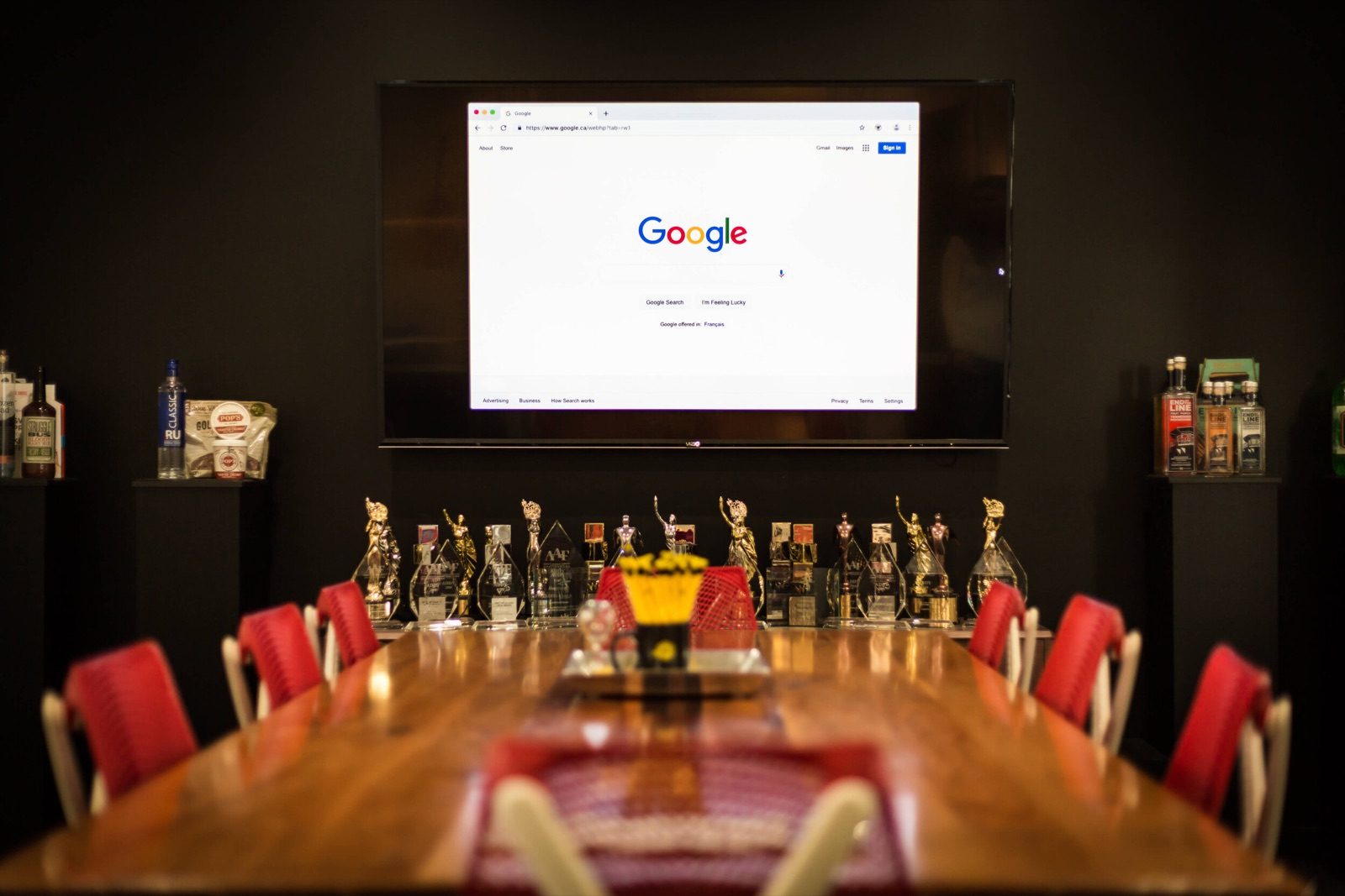 Conference room with red chairs and a Google search page on the wall screen