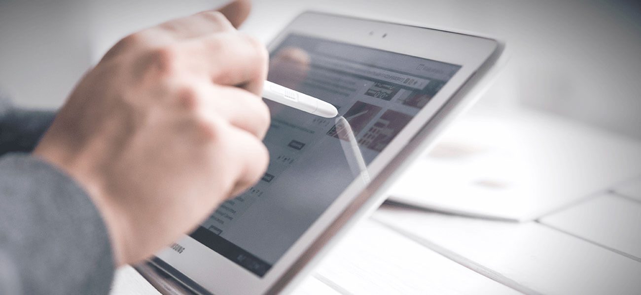 Hand using a stylus on a tablet