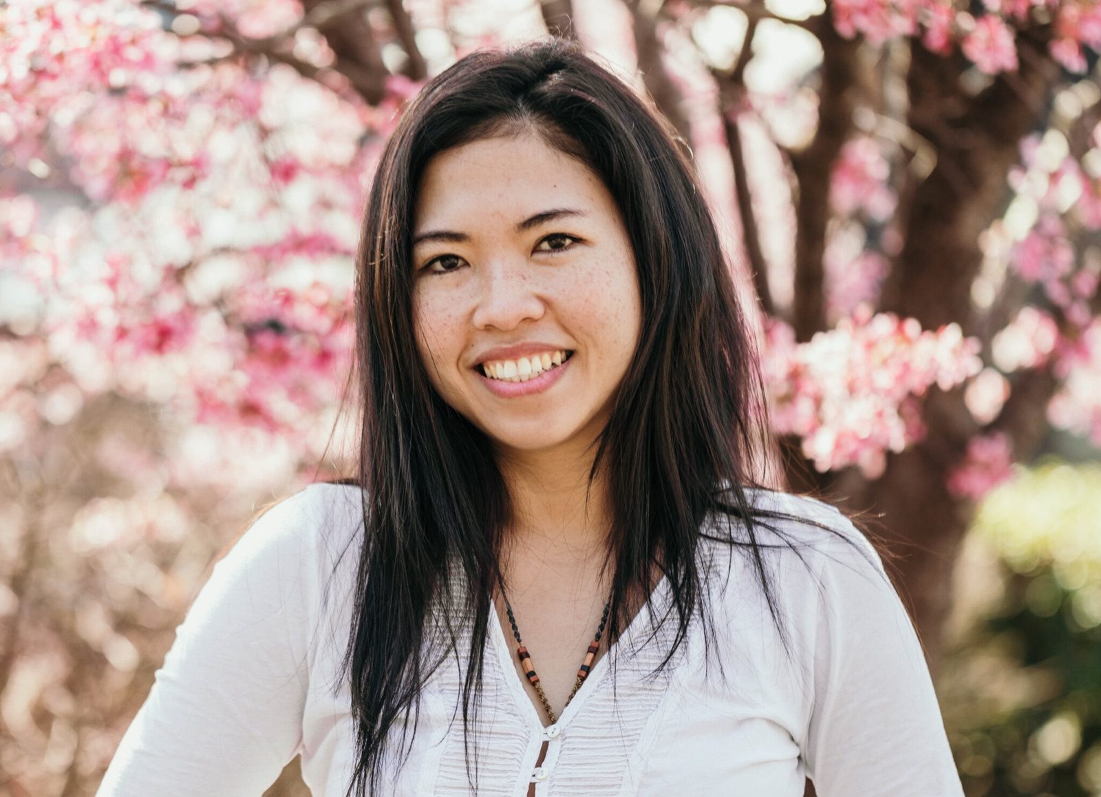 Mary Grace Yap smiling among pink blossoms