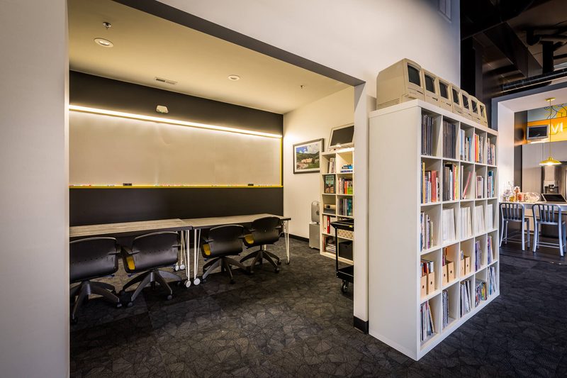 Library nook with white bookshelves and a long black table
