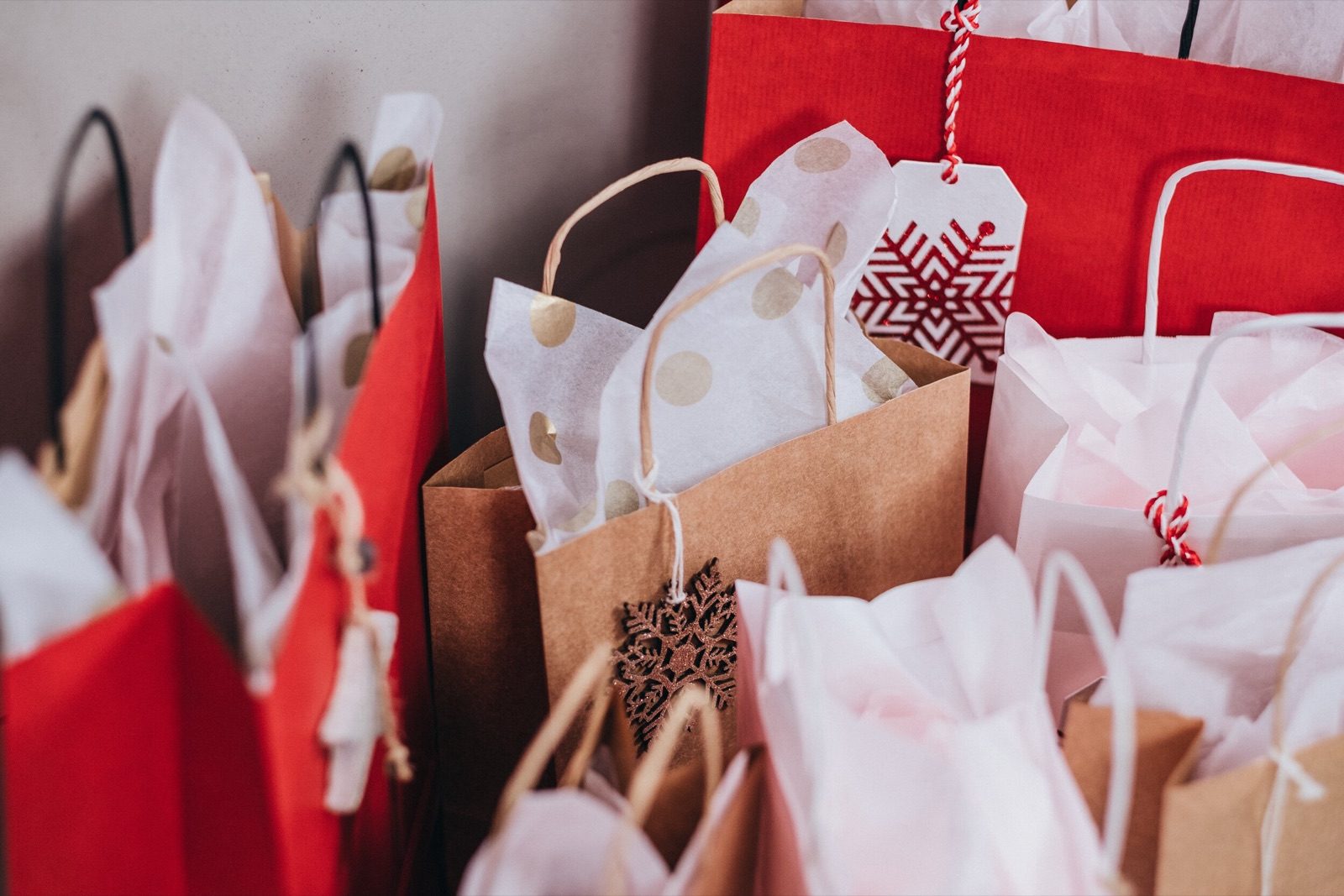 Red and white gift bags with holiday tags