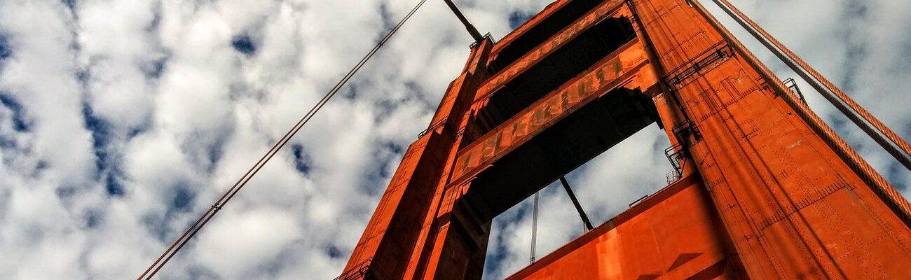 Golden Gate Bridge tower against a cloud-dappled sky