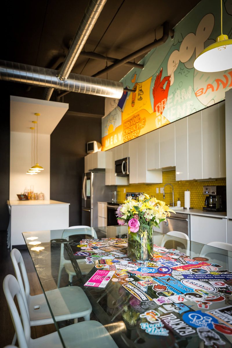 Kitchen table covered in stickers under yellow pendant lamps