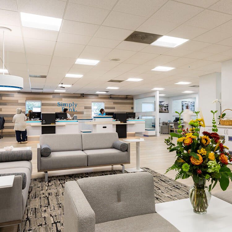 Bank lobby with gray sofas and a vase of flowers