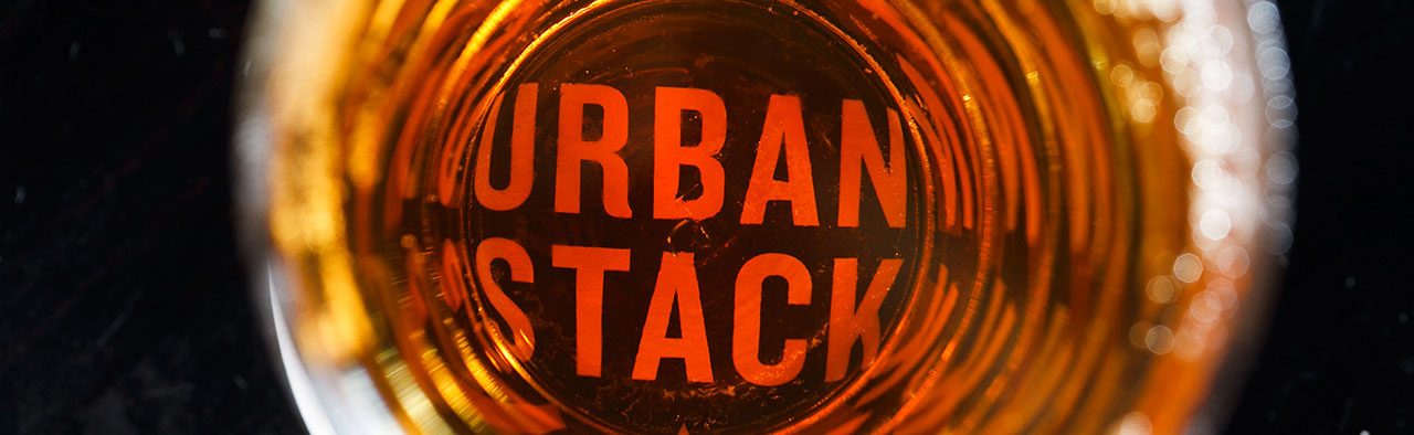 Urban Stack logo over an amber drink