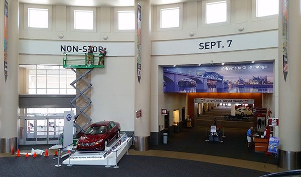 Scissor lift beside Non-Stop and Sept. 7 wall graphics inside the airport terminal