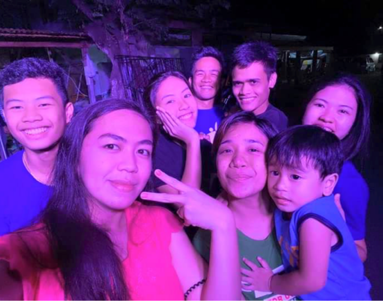 A family group leaning in together for a selfie outdoors at night