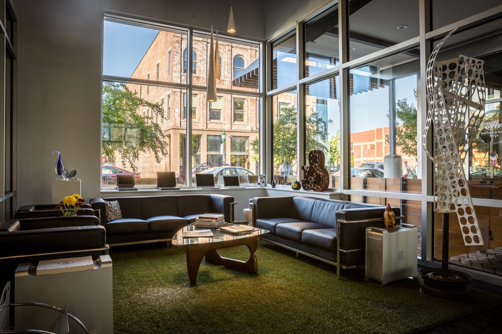 Lounge with leather sofas and floor-to-ceiling windows facing a downtown street
