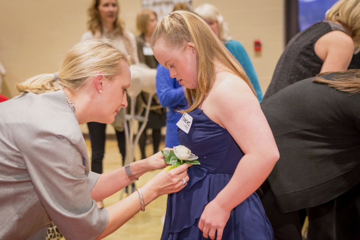 Erin pinning a corsage at a community event
